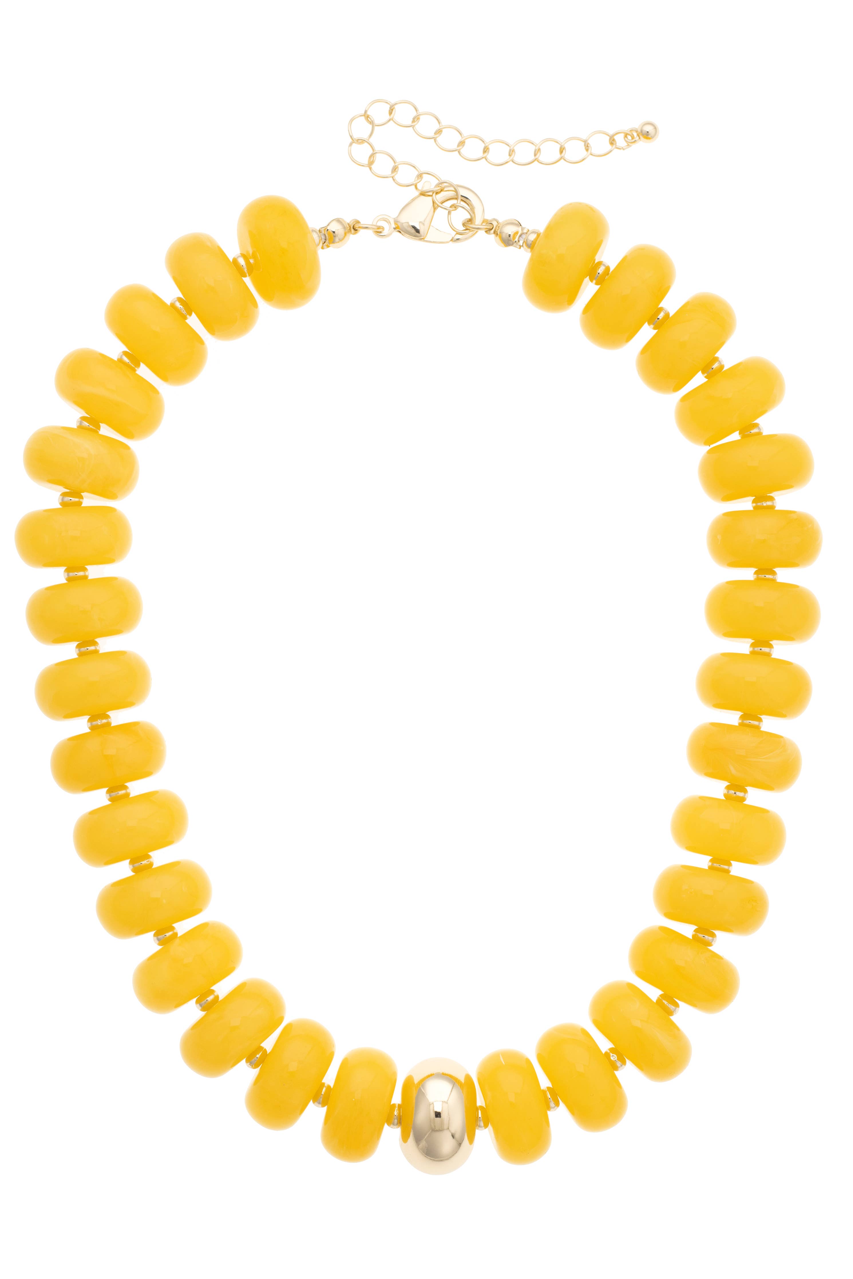 The San Sebastián Beaded Resin Necklace by Canvas Style features large round yellow resin beads accented with a single metallic centerpiece and finished with a gold adjustable chain clasp. This bold statement necklace is perfect for elevating any look.