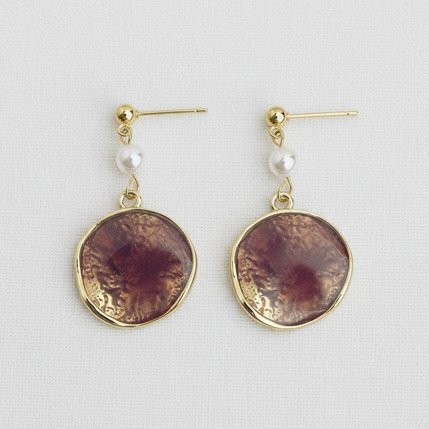 A pair of Ellemadera Purple Enamel Geometric Drop Earrings displayed on a light background.