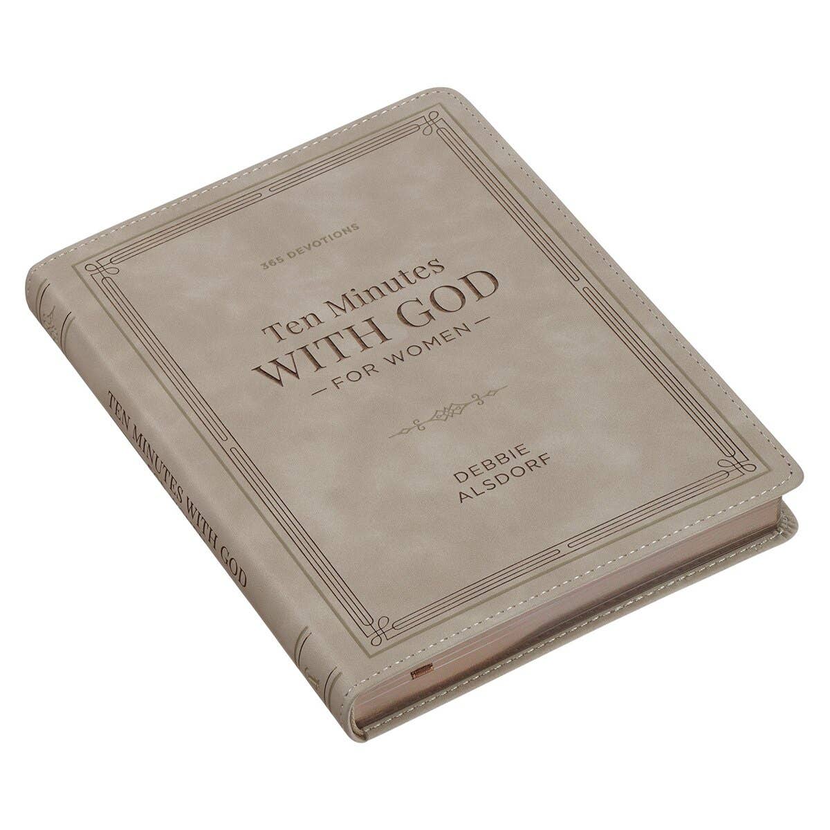 A beige faux leather hardcover book titled “Devotional 10 Minutes with God for Women” by Christian Art Gifts is displayed lying on a white surface.