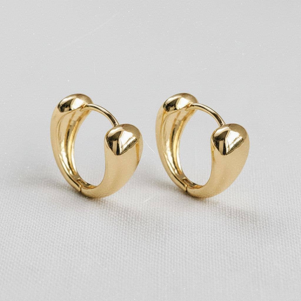 The Contemporary Geometric Drop Earrings by Ellemadera feature a modern, chunky gold design with smooth, rounded shapes and are showcased against a light neutral background.
