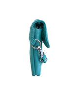 The Cowhide Leather Crossbody Clutch Bag by Roma Leathers, Inc. is shown upright against a white background, featuring turquoise cowhide leather, a silver clasp, and a key ring.