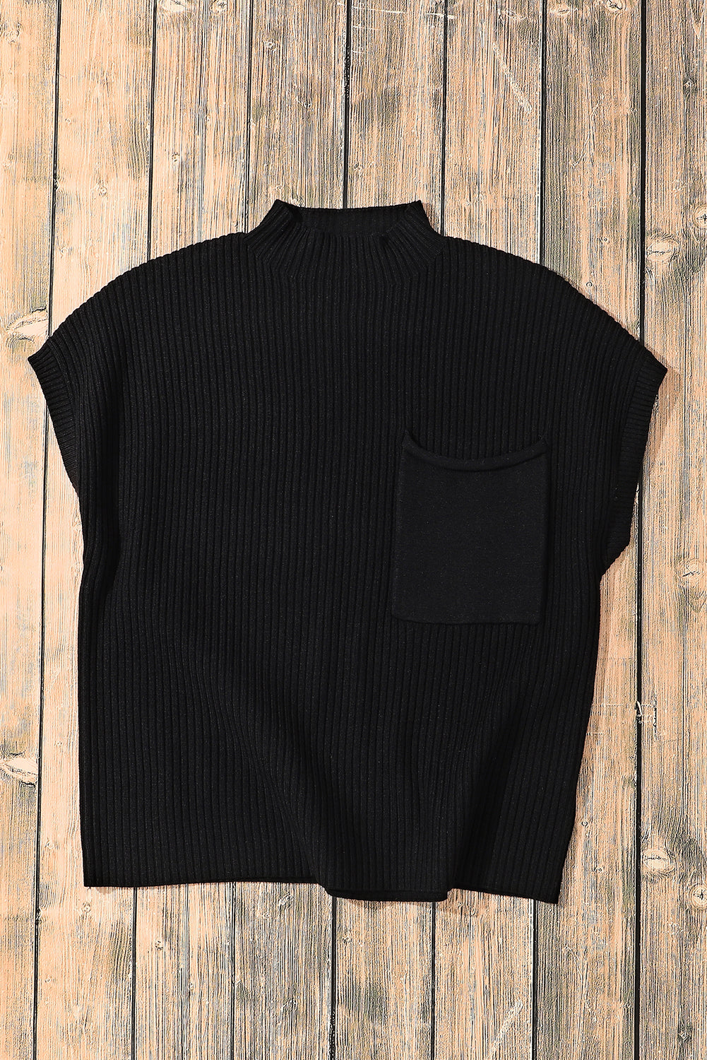 The Shewin Patch Pocket Ribbed Knit Short Sleeve Sweater, displayed on a wooden surface, features a high neck and front pocket. It's a stylish and comfortable choice for transitional weather.