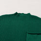 The Shewin Patch Pocket Ribbed Knit Short Sleeve Sweater is a versatile green piece featuring a round neck and chest pocket, perfect for transitional weather, displayed flat on a light surface.