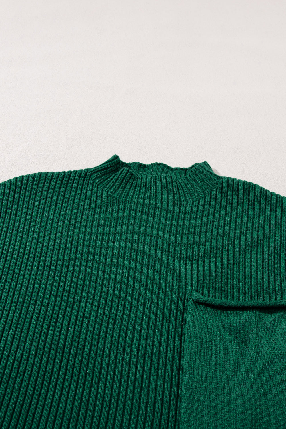 The Shewin Patch Pocket Ribbed Knit Short Sleeve Sweater is a versatile green piece featuring a round neck and chest pocket, perfect for transitional weather, displayed flat on a light surface.