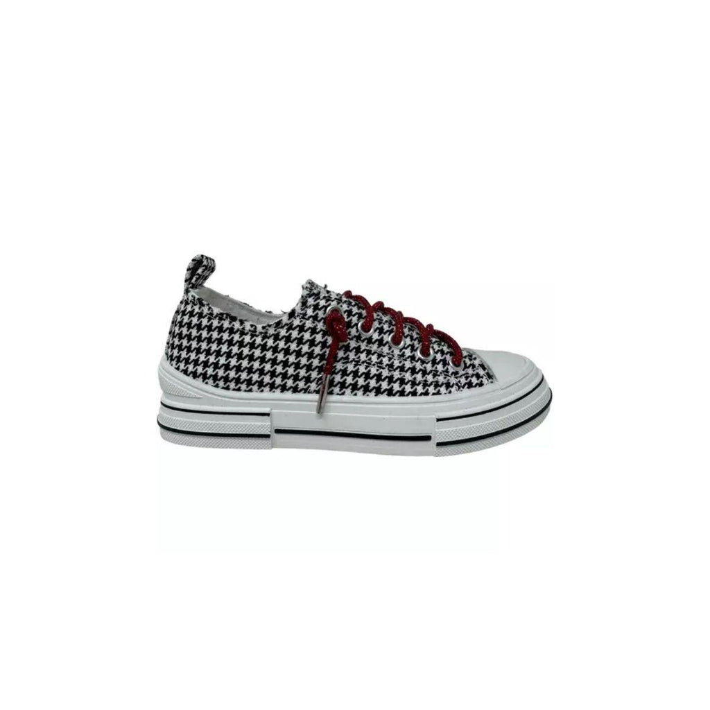 The Aman Tailor Houndstooth Sneaker by VERY G features a bold black and white houndstooth pattern, accented with vibrant red rhinestone shoelaces, a crisp white sole, and a distinct black stripe detail. Displayed in side profile against a white background, this unmistakable statement sneaker offers standout style at every step.