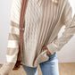 The individual is wearing a Shewin Khaki Cable Knit Colorblock Crew Neck Drop Shoulder Sweater, complemented by a shoulder bag and light blue jeans.