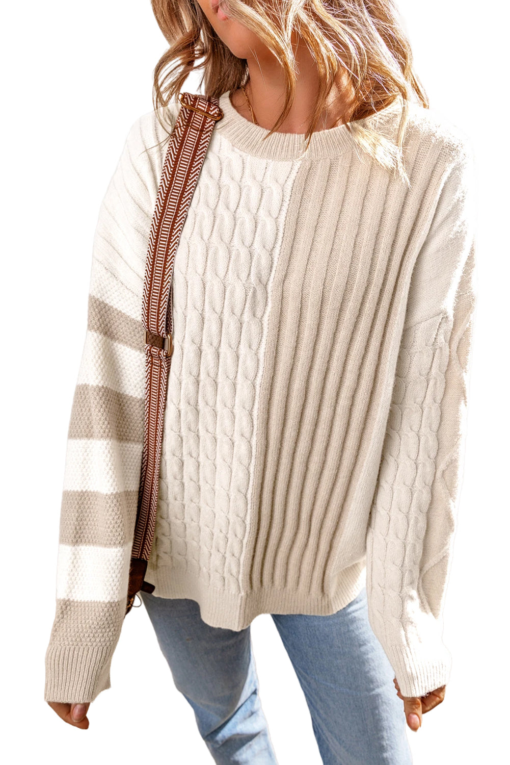 A person is wearing a Shewin Khaki Cable Knit Colorblock Crew Neck Drop Shoulder Sweater with blue jeans and a shoulder bag.