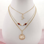 The Alabama Gold & Tube Bead Trio Necklace Set by Seasons Jewelry features three elegant gold-layered chains: a script letter charm, a beaded strand with red and gold beads, and a round pendant engraved with "Alabama Crimson Tide." This collegiate necklace set is the perfect piece of Bama jewelry, beautifully showcased on a white display bust.