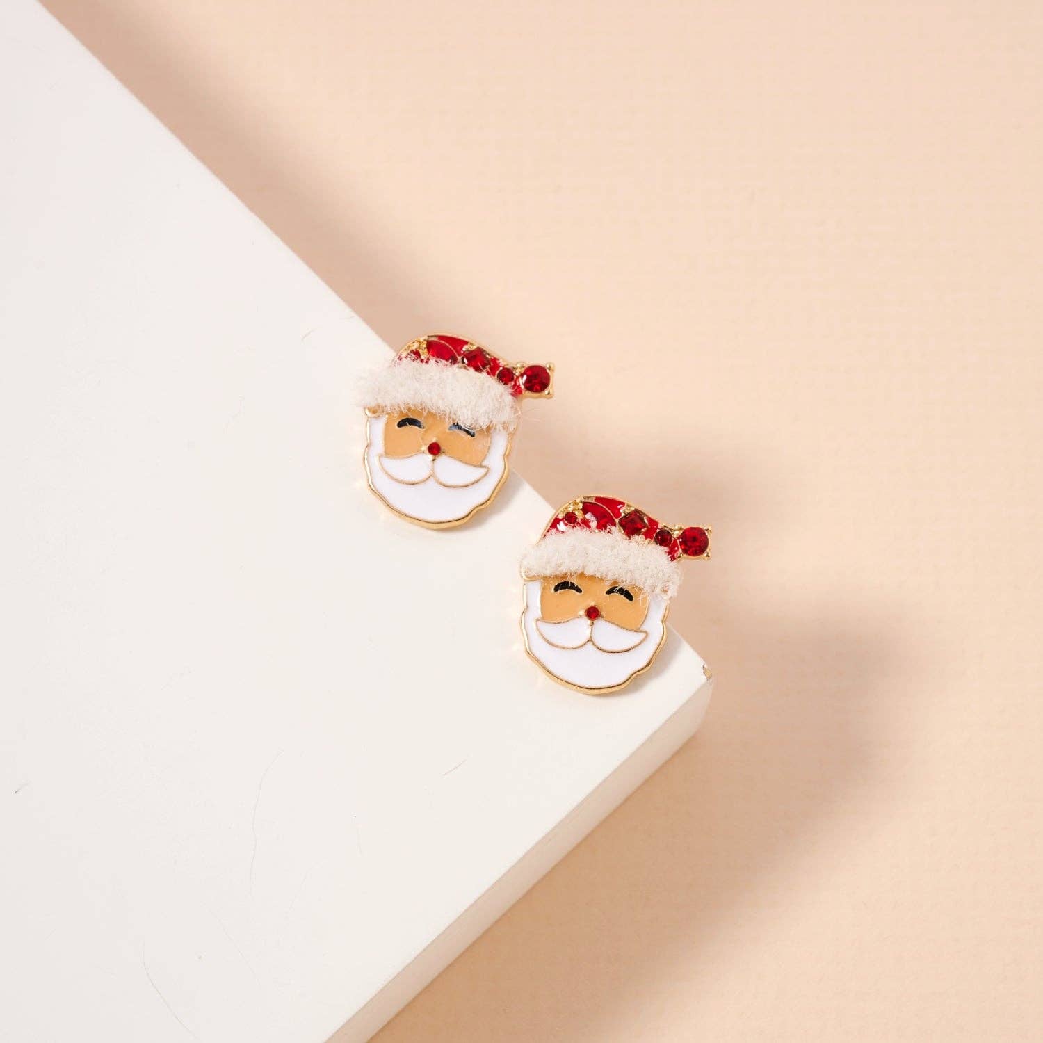 Lilla Haven's Santa Claus Stud Earrings | Red Rhinestone Christmas Earrings are displayed on a white and beige surface, making them the perfect festive addition to your holiday jewelry collection. Main image