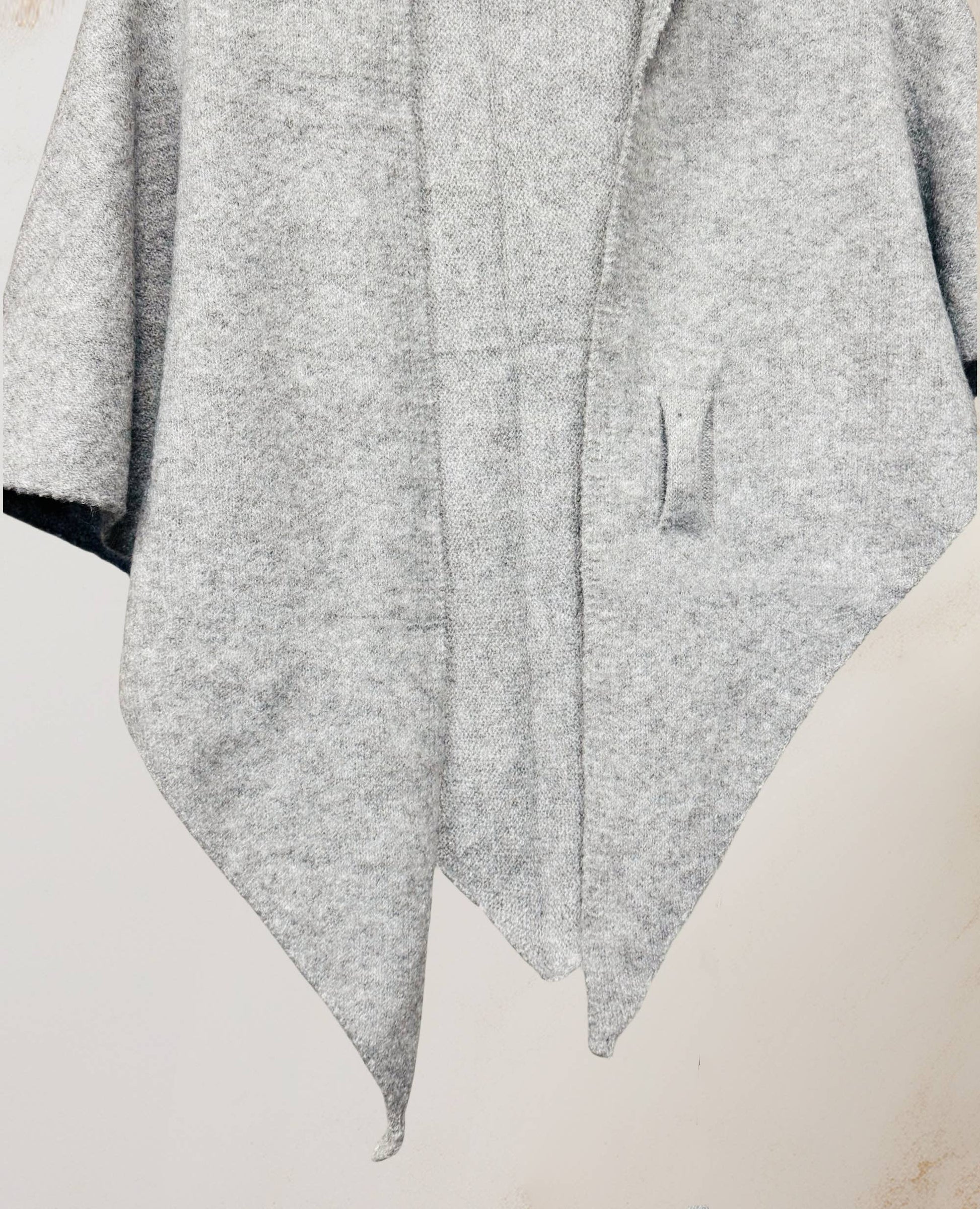 JC Sunny Fashion's Cashmere-Blend Knit Triangle Shawl features a light gray, textured finish, cross-front design, pointed hem, and single pocket, shown against a plain background.