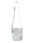 The Roma Leathers, Inc. Cowhide leather crossbody is a small, light gray bag featuring three zippered pockets and an adjustable shoulder strap, shown against a white background.