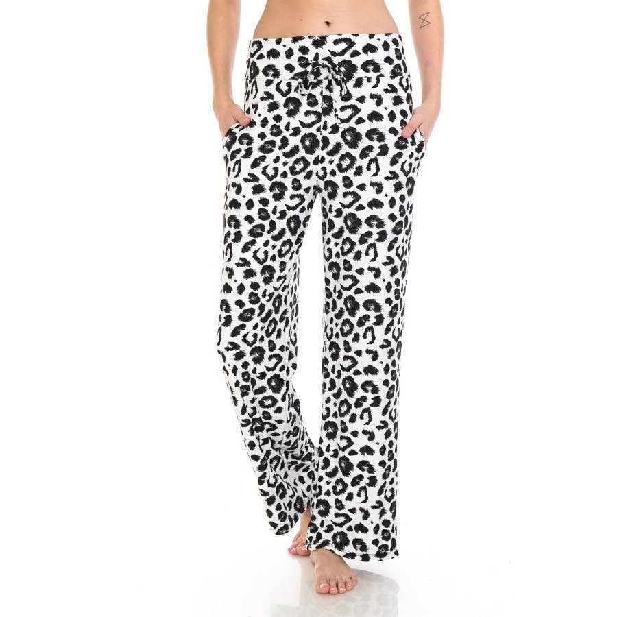 A person wears Leggings Depot Buttery Soft Print Pajama Pants in black leopard print, featuring an elastic waistband, standing barefoot with hands in pockets.
