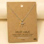 The Anarchy Street Triple Cross Pendant Necklace features gold, silver, and rose gold crosses on a silver chain. Each gold-dipped pendant is displayed on brown "MUST HAVE" packaging for a stylish presentation.