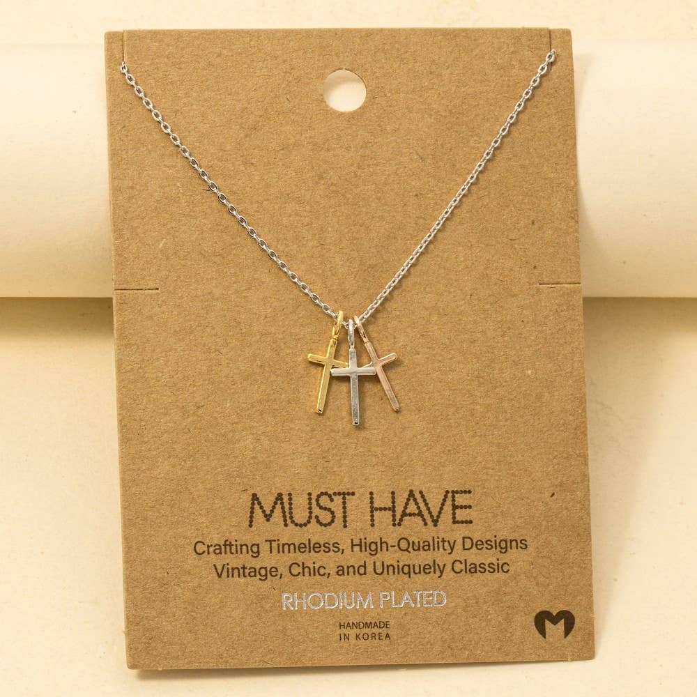 The Anarchy Street Triple Cross Pendant Necklace features gold, silver, and rose gold crosses on a silver chain. Each gold-dipped pendant is displayed on brown "MUST HAVE" packaging for a stylish presentation.