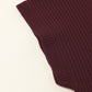 Close-up of Shewin’s burgundy Patch Pocket Ribbed Knit Short Sleeve Sweater fabric, folded at an angle on a light background; perfect for casual style in transitional weather.