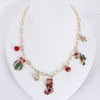 Seasons Jewelry’s Vintage Christmas Charm Necklace showcases vintage-style charms—stocking, candy cane, ornament—accented with red and gold beads, all elegantly presented on a white bust.