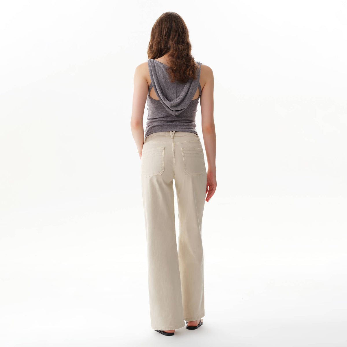 Back view of a person wearing Faire Off White Mid Rise Straight Pants and a grey hooded tank top.
