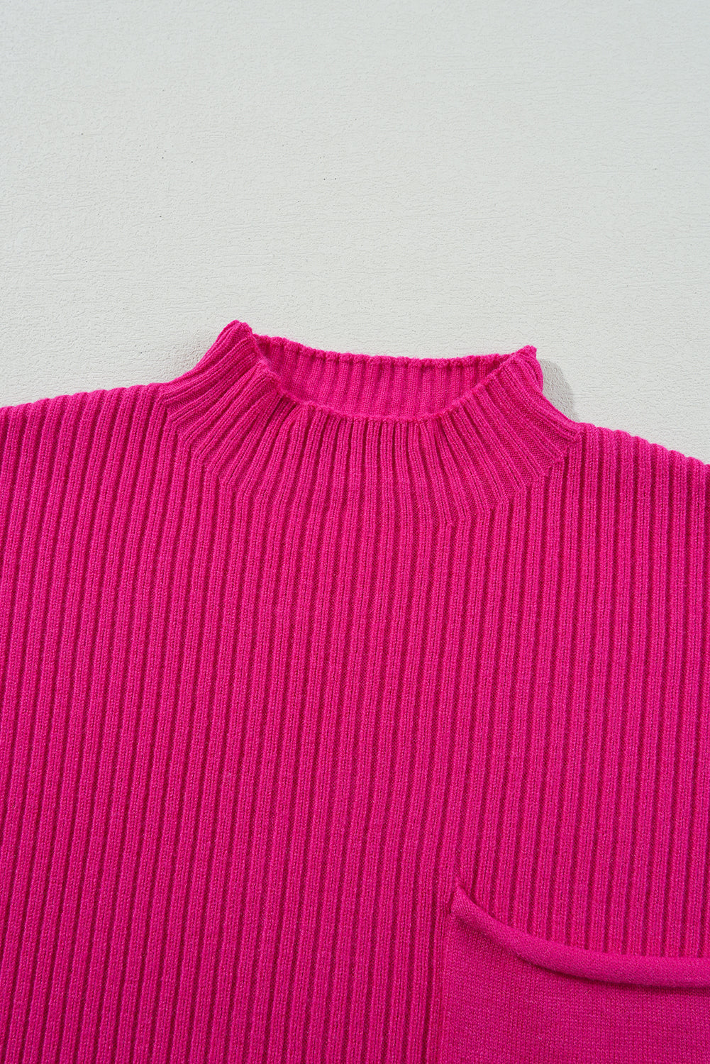 The Shewin "Patch Pocket Ribbed Knit Short Sleeve Sweater" is a bright pink, cozy knit with a high neckline. Ideal for transitional weather, it displays a ribbed texture and partially reveals a pocket.