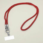 The Sensibling Corp. Rhinestone Phone Lanyard Necklace, shown in red with a sparkly rhinestone strap, a silver metal clasp, and a blank rectangular name tag, is displayed against a plain, light-colored background.