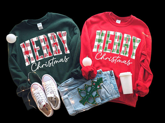 Two Merry Christmas Buffalo Plaid Sweatshirts by TheKingShirt—one green, one red—are styled with jeans, sneakers, and festive props. These unisex cotton shirts are perfect for the holiday season.