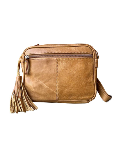 The Cowhide Leather Crossbody by Roma Leathers, Inc. features tan cowhide leather, a rectangular shape, adjustable strap, front zipper pocket, and tassel zipper pull, displayed against a white background.