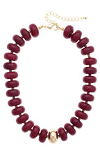 Experience the bold elegance of the San Sebastián Beaded Resin Necklace by Canvas Style—a short statement piece adorned with large, round maroon resin beads and a striking central gold bead, finished with a gold chain and clasp.