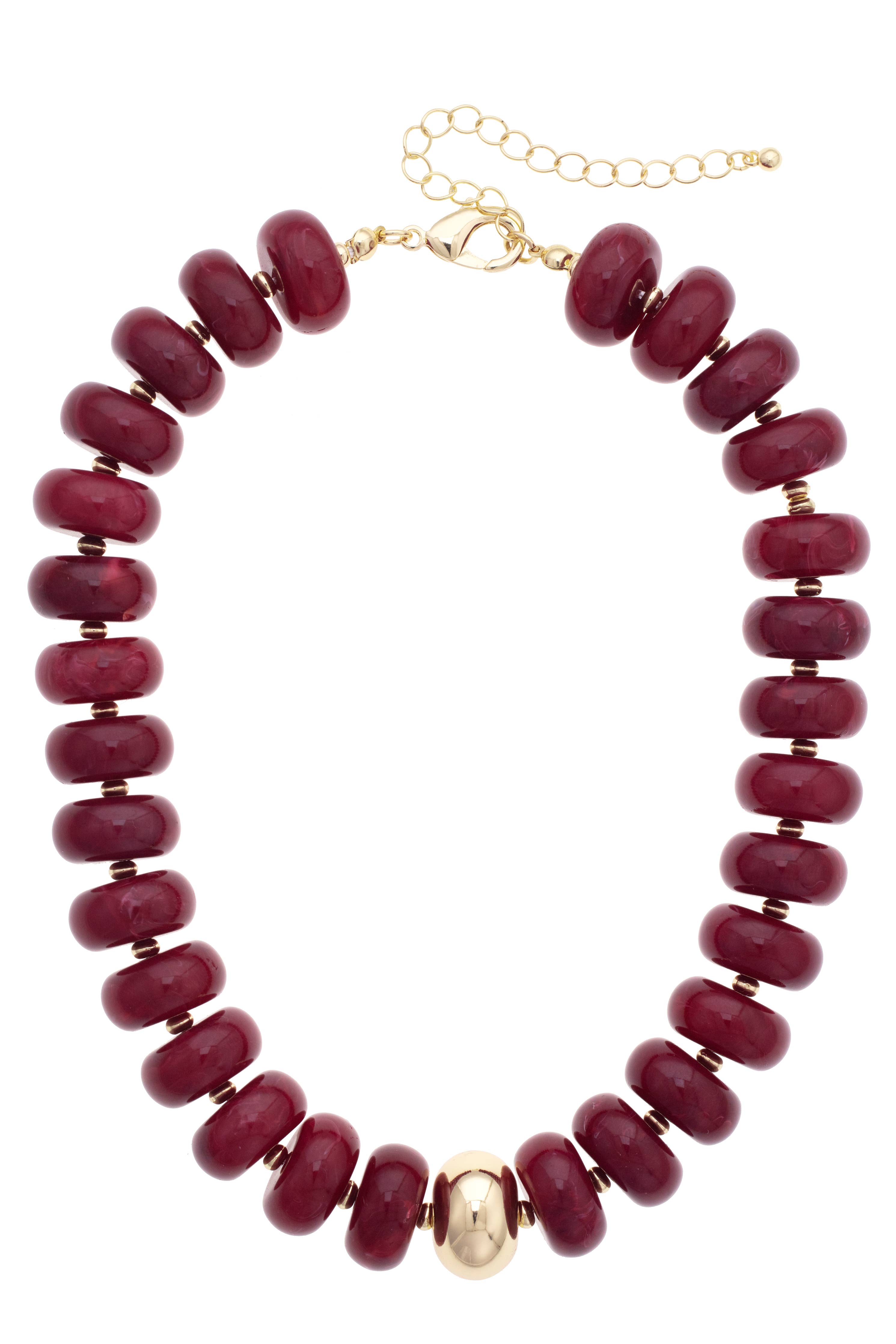 Experience the bold elegance of the San Sebastián Beaded Resin Necklace by Canvas Style—a short statement piece adorned with large, round maroon resin beads and a striking central gold bead, finished with a gold chain and clasp.