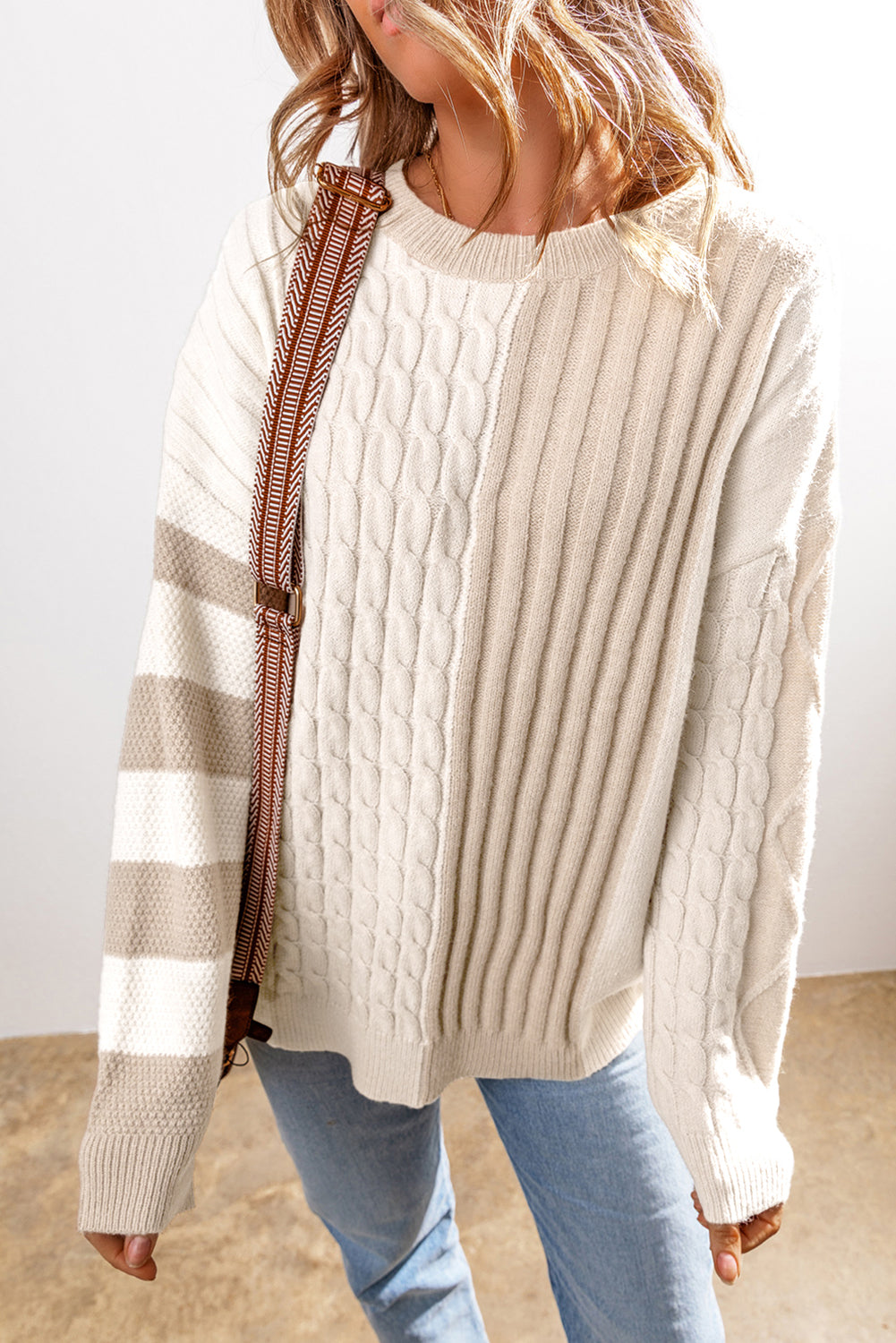 A person in a Shewin Khaki Cable Knit Colorblock Crew Neck Drop Shoulder Sweater is paired with light blue jeans.