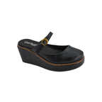The Me Time Wedge by CORKY’S FOOTWEAR INC features a black wedge-heeled Mary Jane design with a gold buckle strap, brown stitching around the sole, and the Corkys Footwear logo on the insole. These black wedges for women offer classic style combined with all-day comfort, making them an ideal choice for anyone seeking comfortable wedge sandals.