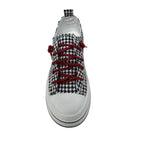 The Aman Tailor Houndstooth Sneaker by VERY G features a striking black and white houndstooth pattern, bold red rhinestone shoelaces, a crisp white sole, and a pull tab. Shown from a top-down perspective, this statement shoe is designed to turn heads.