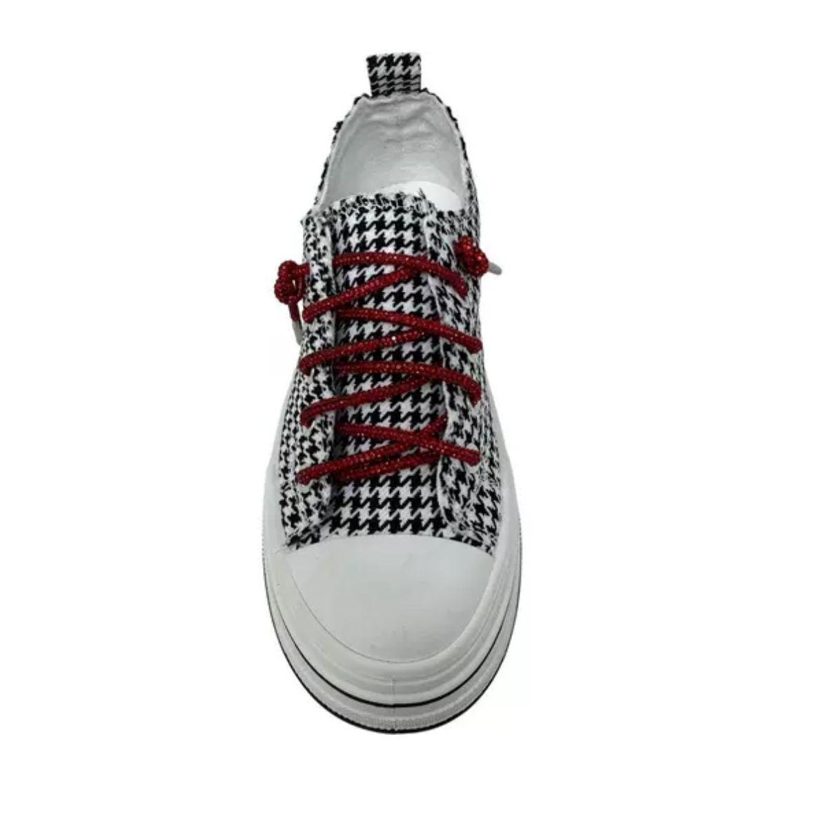 The Aman Tailor Houndstooth Sneaker by VERY G features a striking black and white houndstooth pattern, bold red rhinestone shoelaces, a crisp white sole, and a pull tab. Shown from a top-down perspective, this statement shoe is designed to turn heads.