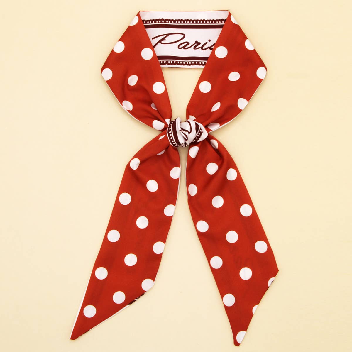 The ACCITY Skinny Floral Ribbon Scarf for Hair or Handbag (CWASC0067) is a chic red faux silk accessory with white polka dots, "Paris" detail on a contrasting strip, perfect to accent any outfit with an elegant touch.