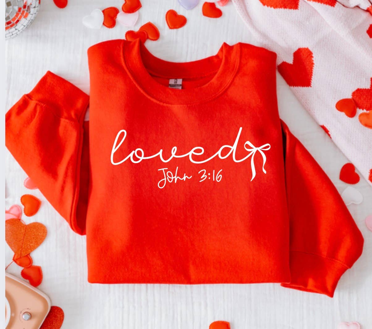 The Festivitees Loved John 3:16 Sweatshirt features "loved" in white text with red and pink hearts—a stylish unisex Christian faith piece.