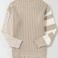 The Shewin Khaki Cable Knit Colorblock Crew Neck Drop Shoulder Sweater features a ribbed texture, highlighting cable-knit on the left sleeve and a striped design on the right.