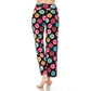 A person stands barefoot against a white background wearing Leggings Depot Buttery Soft Print Pajama Pants featuring a colorful donut pattern and an elastic waistband.