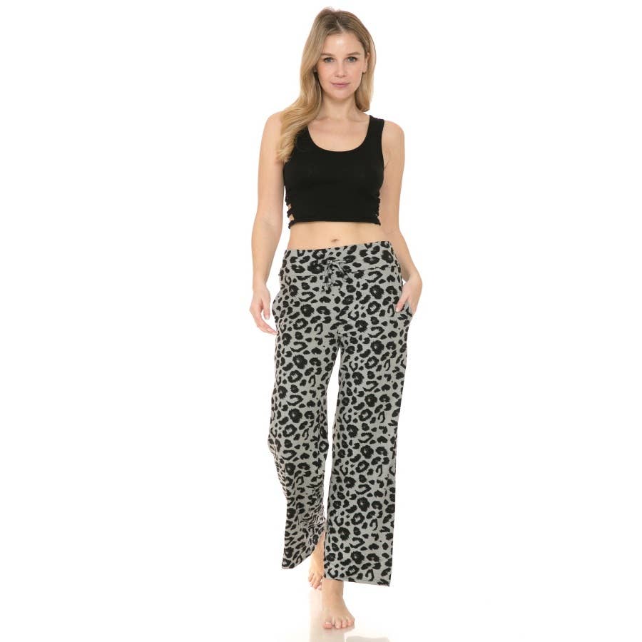 A woman stands barefoot against a white background, wearing Leggings Depot's Buttery Soft Print PJ Pants in high-rise gray leopard print with pockets, paired with a black sleeveless crop top.