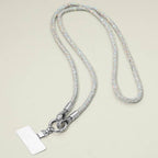 A sparkling, textured Rhinestone Phone Lanyard Necklace by Sensibling Corp. features a silver cord reminiscent of rhinestone straps and a clasp holding a blank rectangular badge.