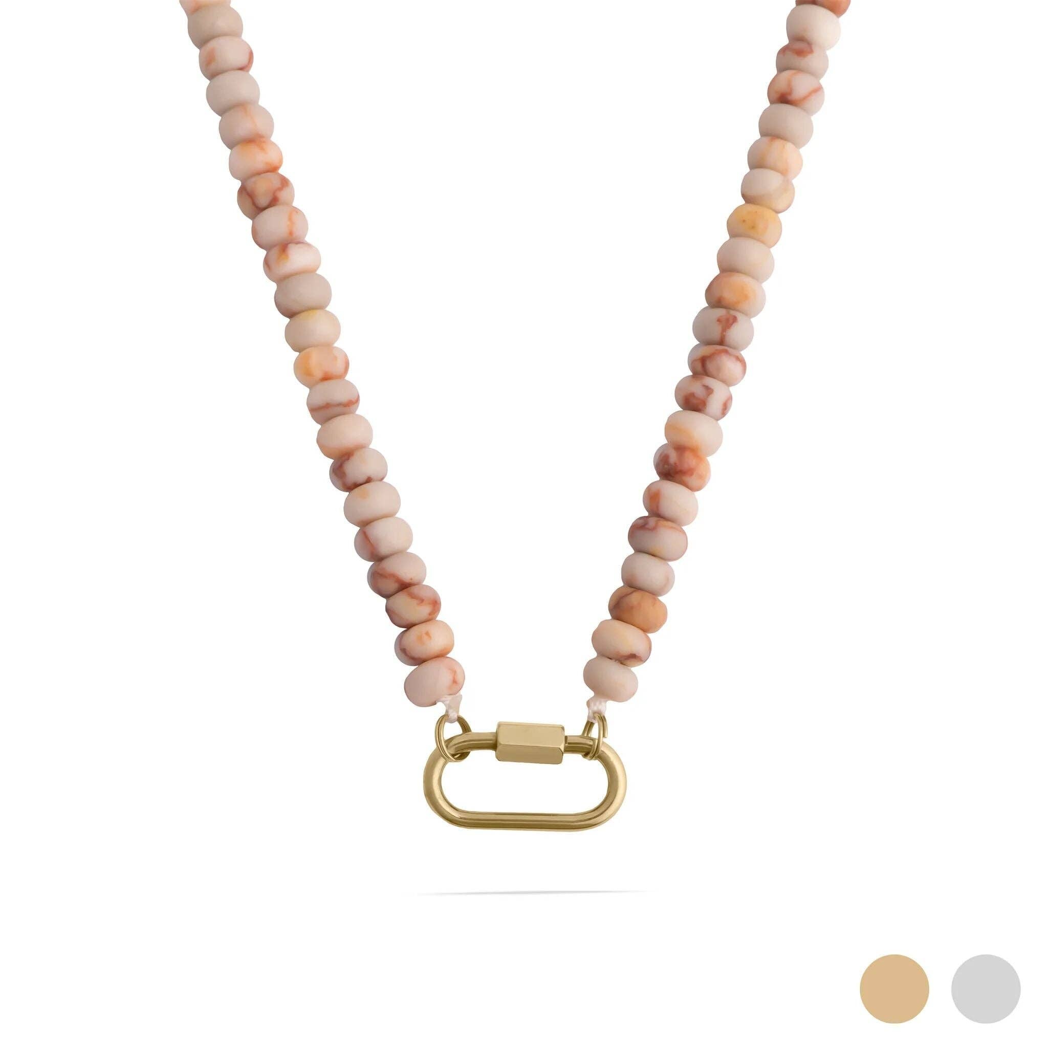 The WJW Stainless Steel Chunky Glass Bead Carabiner Necklace features pinkish-tan round glass beads and a gold carabiner clasp, displayed on a white background with two color swatches in the lower right corner. This statement necklace brings playful elegance to any outfit. Main image