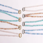 Eight pastel-colored beaded lanyards are arranged in pairs on a white surface, each adorned with either a gold or silver clasp at one end, reflecting the elegant design of the WJW Stainless Steel Turquoise Chunky Bead Carabiner Necklace.