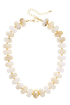 The San Sebastián Beaded Resin Necklace by Canvas Style is a striking statement piece, designed with round white resin beads, gold spacer accents, a central gold bead, and an adjustable gold chain and clasp.