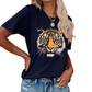 A woman wears the ACCITY Women’s Tiger Print T-Shirt—a relaxed-fit tee with a bold tiger face—styled with blue denim jeans and gold layered necklaces.