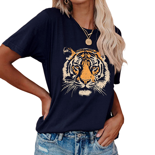 A woman wears the ACCITY Women’s Tiger Print T-Shirt—a relaxed-fit tee with a bold tiger face—styled with blue denim jeans and gold layered necklaces.
