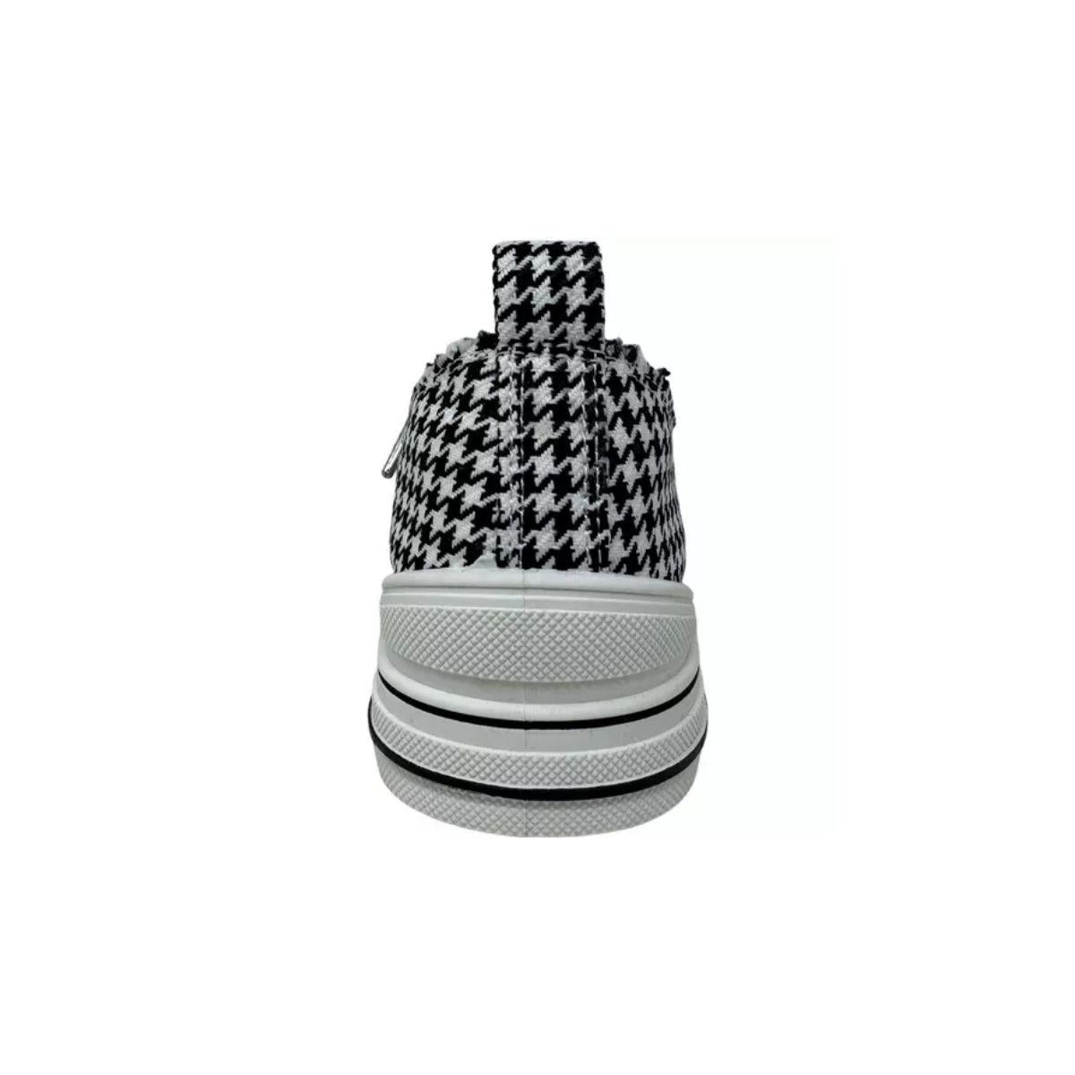 Centered on a plain white background, this image highlights the rear view of the VERY G Aman Tailor Houndstooth Sneaker, featuring a classic black and white houndstooth pattern, a crisp white rubber sole, and a practical pull tab at the heel.