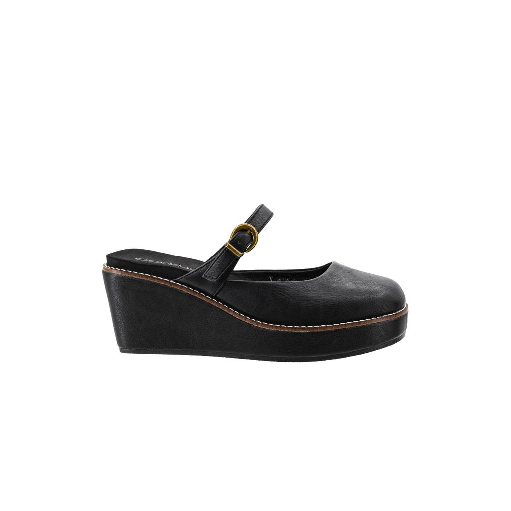 The Me Time Wedge by CORKY’S FOOTWEAR INC is a black platform wedge shoe featuring a closed toe, Mary Jane strap, and gold buckle, displayed in profile against a white background. Perfect for those seeking comfortable wedge sandals, these black wedges combine classic style with modern elegance women will love.