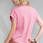 A blonde woman faces away, wearing Shewin's Patch Pocket Ribbed Knit Short Sleeve Sweater in pink paired with a brown skirt, ideal for transitional weather.