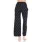 A person stands barefoot facing away in Leggings Depot's Buttery Soft Print Pajama Pants, featuring a small white bow pattern and elastic waistband, set against a plain white background.