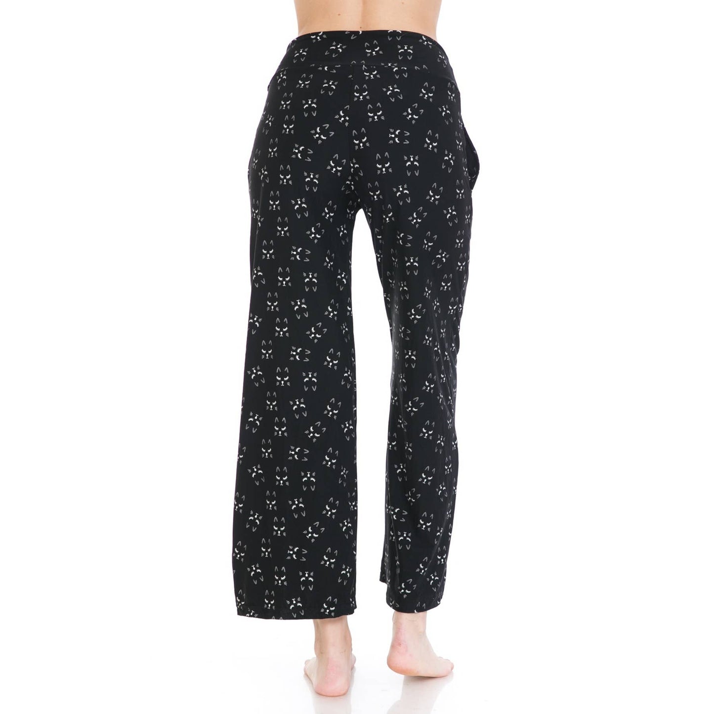 A person stands barefoot facing away in Leggings Depot's Buttery Soft Print Pajama Pants, featuring a small white bow pattern and elastic waistband, set against a plain white background.