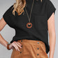 A woman wears Shewin's Patch Pocket Ribbed Knit Short Sleeve Sweater in black with a wooden pendant necklace and a high-waisted, buttoned tan skirt—perfect for transitional weather.