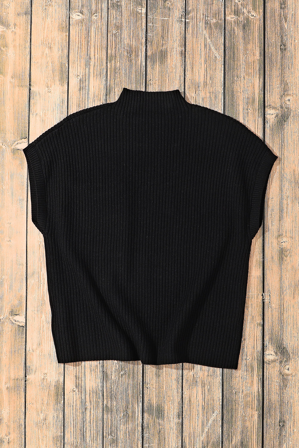 The Shewin Patch Pocket Ribbed Knit Short Sleeve Sweater in black is a versatile choice for transitional weather, beautifully displayed on a textured wooden floor.