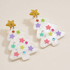 Add a festive sparkle to your look with the Glittery Christmas Tree Drop Earrings by Lilla Haven. These holiday acrylic earrings feature two pastel-colored, tree-shaped drops adorned with pearl-like beads, rhinestones, and gold glitter star toppers—perfect for making a cheerful holiday statement. Displayed on a light background, they capture the whimsical spirit of the season.